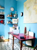 Cuisine-salle à manger originale avec murs peints en bleu et table et chaises