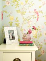 Détail de l'armoire de chevet avec cadre photo et roses dans un vase