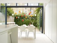 Cuisine-salle à manger moderne avec portes-fenêtres ouvertes sur le jardin