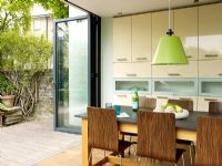 Cuisine-salle à manger moderne avec portes ouvertes sur le jardin