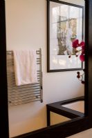 Miroir de salle de bain montrant un radiateur sèche-serviettes en réflexion