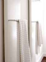 Serviettes suspendues à des radiateurs dans la salle de bain blanche moderne