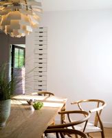 Salle à manger moderne avec chaises Hans Wegner Y et pendentif artichaut Poul Henningsen