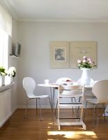 Salle à manger contemporaine blanche avec table Piet Hein et chaises papillon par Arne Jacobsen