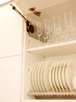Détail de l'armoire de cuisine moderne ouverte montrant des assiettes et des verres