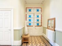 Hall d'entrée avec sol carrelé à motifs et portes vitrées