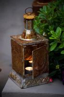 Lanterne marocaine avec bougie allumée dans jardin