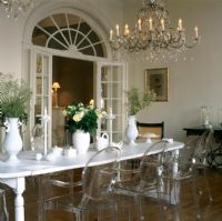 Vase de fleurs sur table à manger avec lustre lumineux et chaises Louis Ghost