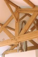 Poutres en bois et cheminée en acier au plafond