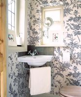 Salle de bain avec papier peint fleuri et lavabo
