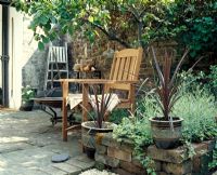 Chaise en bois sur terrasse dans petit jardin
