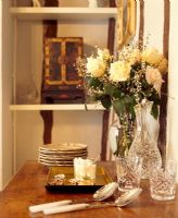 Vase de fleurs, verres et cuillères sur buffet dans la salle à manger