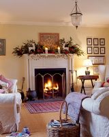 Salon avec cheminée décorée et feu brûlant à Noël