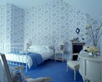 Chambre avec papier peint à motifs et tapis bleu