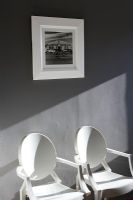 Deux chaises contre un mur gris