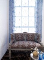 Canapé vintage devant une fenêtre rideau