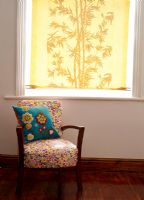 Fauteuil à motifs floraux devant la fenêtre avec store jaune