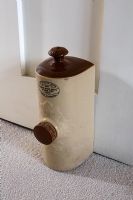 Bouteille d'eau chaude victorienne utilisée comme butoir de porte