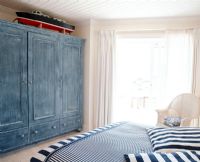 Chambre ensoleillée avec couvre-lit à rayures et oreillers