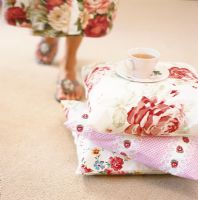 Section basse de femme et tasse de thé sur une pile d'oreillers