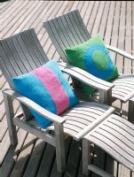 Deux chaises de plage en bois avec des oreillers colorés