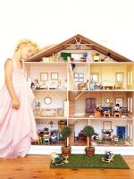 Fille jouant avec maison de poupée