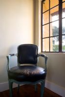 Chaise en cuir antique usée dans un coin à côté de la fenêtre