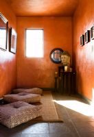 Petite salle de yoga aux murs orange brûlé