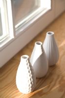 Vases blancs sur le rebord de la fenêtre en bois