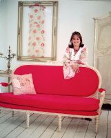 Femme s'appuyant sur un canapé vintage rouge vif