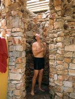 Homme se baignant dans une douche en pierre