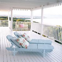 Deux chaises longues avec oreillers sur balcon
