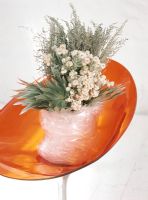 Bouquet de fleurs enveloppé de plastique sur une chaise orange