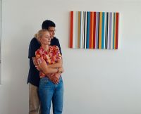 Homme tenant une femme à côté d'une peinture moderne
