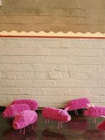 Un mur de briques et des jouets roses