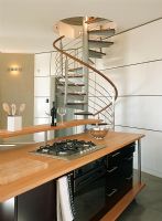 Une cuisine contemporaine en bois et des escaliers en colimaçon