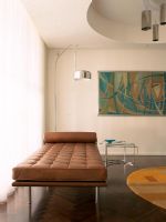 Canapé en cuir et lampadaire avec photo au mur