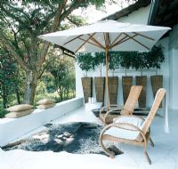 Terrasse patio avec des meubles en osier et un tapis en peau d'animal