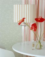 Pichet en verre avec des fleurs rouges sur table