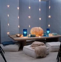 Table à manger basse avec coussins et brins de lumières en forme d'étoile