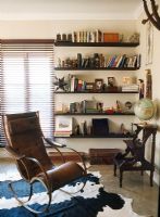 Un fauteuil en cuir marron et une bibliothèque