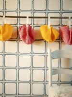 Collection de bonnets de bain roses et jaunes séchant sur une corde à linge