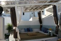 Coin salon couvert sur terrasse avec verrière en bambou