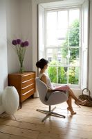 Femme assise sur une chaise 'Swan' d'Arne Jacobsen