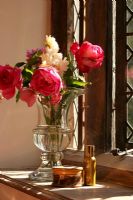 Roses roses dans un vase en verre sur le rebord de la fenêtre