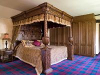 Chambre traditionnelle avec tapis tartan et lit à baldaquin
