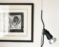 Un dessin contemporain blanc et noir sur le mur et une lampe