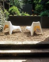 Chaises de jardin modernes sur une terrasse en gravier