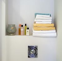 Articles de toilette et serviettes sur l'étagère de la salle de bain