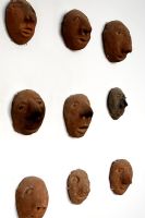 Collection de têtes d'argile sur mur, détail